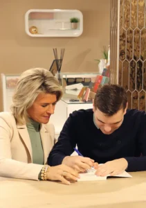 Duuk heeft autisme. Zijn moeder Debby zit naast hem. Op de foto signeren ze het boek 'ik wens iedereen een Duuk', bij de boeklancering.